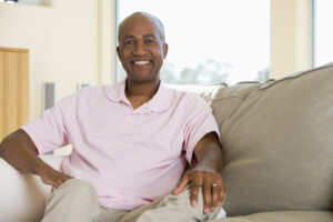 man sitting in living room smiling SFZlUK30Bj SBI 301056370